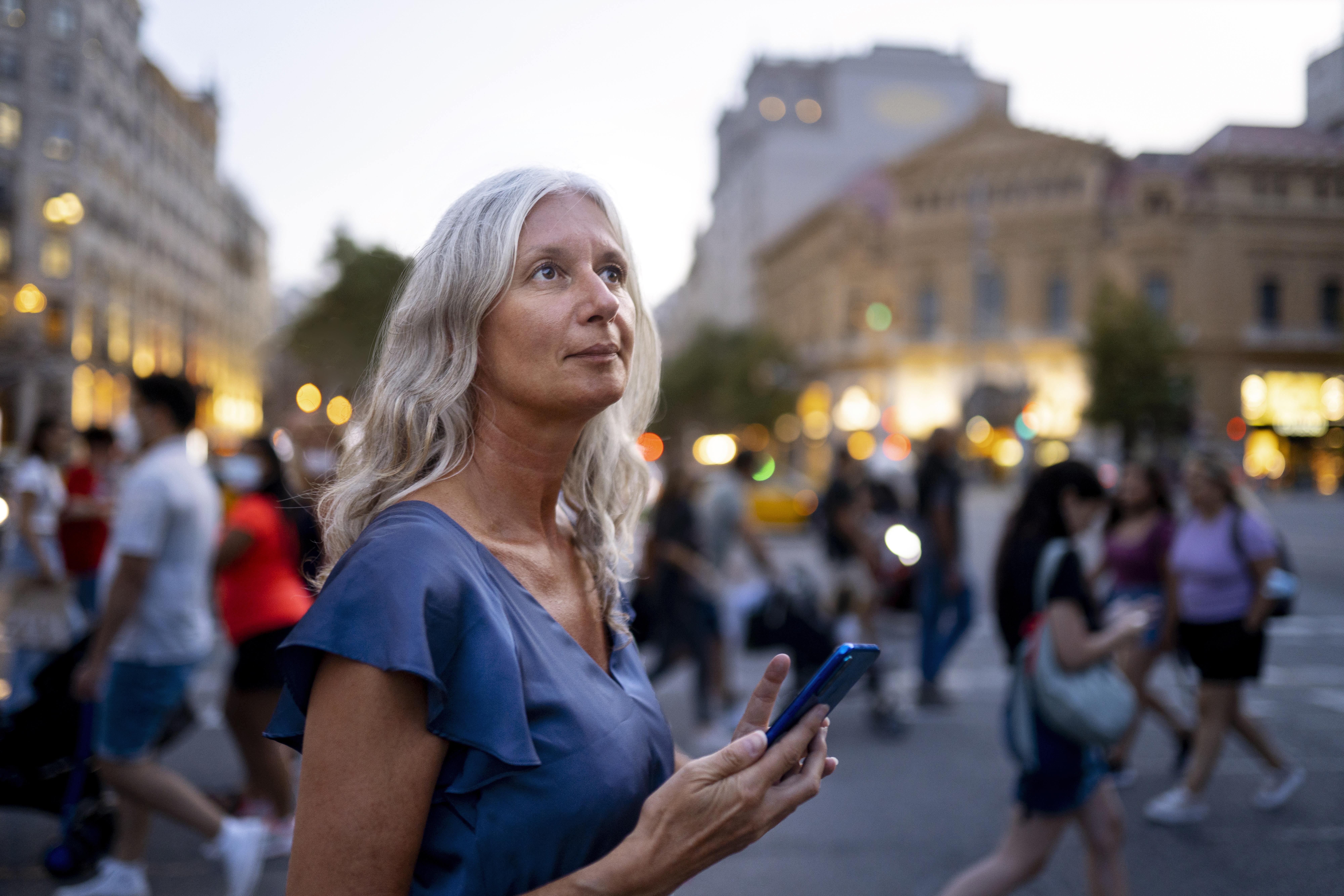 Femme pensive au milieu d’une foule en ville